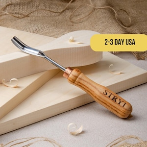 May include: A wood carving tool with a curved blade and a wooden handle. The handle is engraved with the word "STRYI".