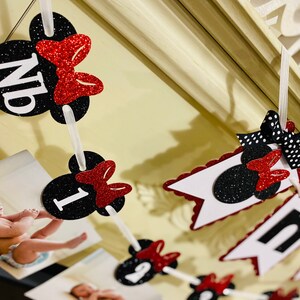 May include: Black and red Minnie Mouse themed photo banner with the word "one" and numbers 1, 2, 3, and 4. The banner is strung with white ribbon and has black and white polka dot bows.