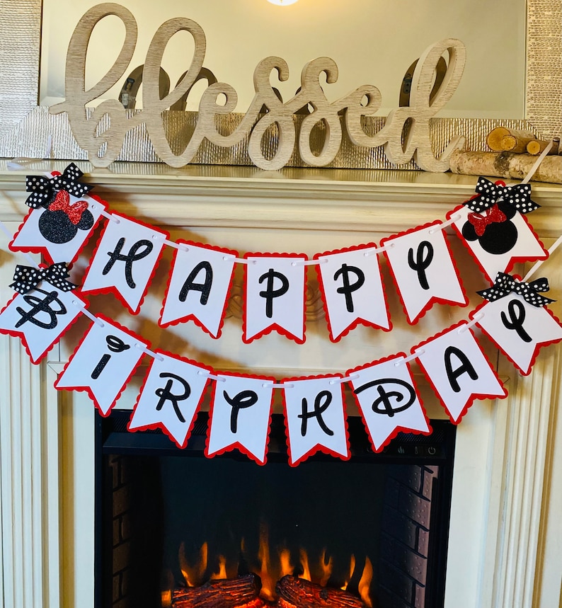 May include: A white and red banner with black letters that reads "Happy Birthday". The banner is decorated with black and red Minnie Mouse heads.
