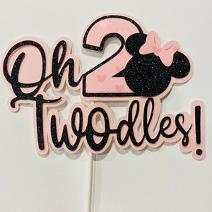 May include: Pink and black glitter cake topper with the text "Oh Twoodles!" and a number 2 with a pink Minnie Mouse head.