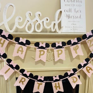 May include: Pink and black birthday banner with gold glitter letters spelling "Happy Birthday" and "2nd". The banner features Minnie Mouse ears with black bows.