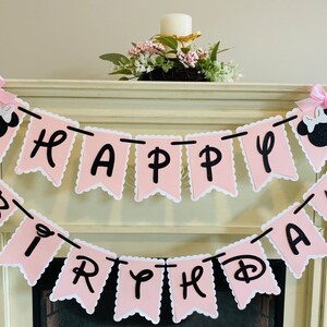 May include: Pink and black banner with the words "Happy Birthday" in black letters. The banner is decorated with two black and pink Minnie Mouse heads.