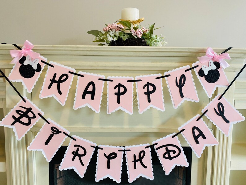 May include: Pink and black banner with the words "Happy Birthday" in black letters. The banner is decorated with two black and pink Minnie Mouse heads.