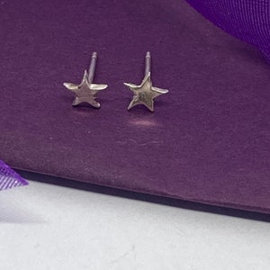 Delicate tiny star fine silver studs with sterling silver backs and posts.