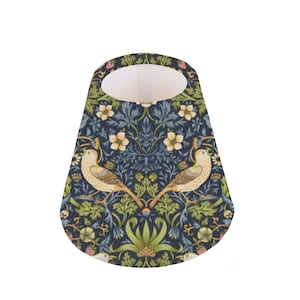 May include: A cone-shaped lampshade with a blue background and a floral pattern featuring birds, leaves, and flowers. The lampshade is made of fabric and has a white interior.
