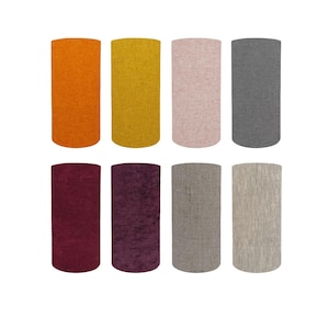 May include: Eight cylindrical lampshades in various colours, including orange, yellow, pink, grey, burgundy, purple, taupe, and beige. The lampshades have a textured fabric appearance, arranged in two rows of four.
