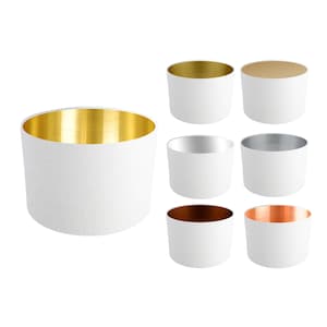 May include: Set of 7 white lampshades with different coloured metallic interiors. The lampshades are cylindrical and have a smooth, fabric-like texture.
