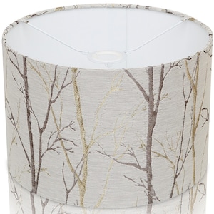 May include: A white lampshade with a beige and gold fabric pattern of branches. The fabric has a subtle texture.
