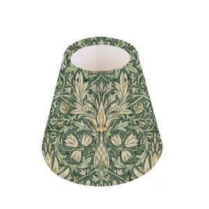 May include: A green and cream lampshade with a floral pattern. The pattern features stylized leaves, flowers, and a central motif.