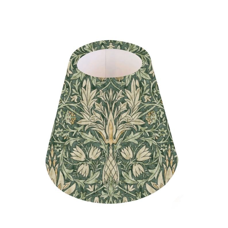 May include: A green and cream lampshade with a floral pattern. The pattern features stylized leaves, flowers, and a central motif.