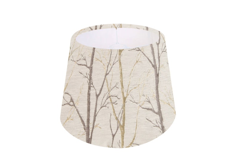 May include: A beige lampshade with a pattern of brown branches on a white background.