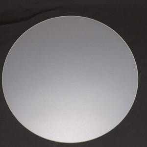 May include: A circular, silver-coloured metal disc. The disc has a smooth, matte finish and is set against a dark background. The shape is a perfect circle.
