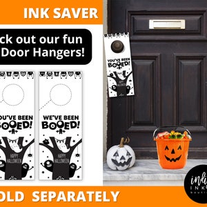 Pu&ograve; includere: Decorazioni per porte di Halloween in bianco e nero con le scritte "You've Been Booed!" e "We've Been Booed!". Sono visibili anche un secchio di zucca arancione e una zucca bianca dipinta.