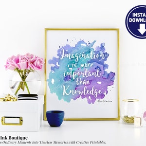 Pode incluir: Uma impressão de aquarela com moldura dourada apresentando uma citação de Albert Einstein: "A imaginação é mais importante do que o conhecimento." A citação está escrita em branco sobre um fundo de aquarela azul e roxo.