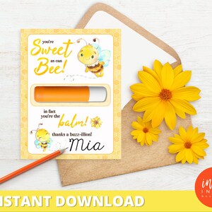 Op de afbeelding: Een gele en zwarte lipbalm-favorenkaart met de tekst "You're Sweet as can Bee! In fact you're the balm! Thanks a buzz-illion! Mia".