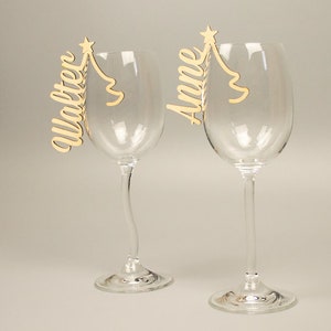 Lettering as a place card made of natural wood for glasses with a Christmas tree