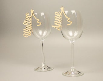 Lettering as a place card made of natural wood for glasses with a Christmas tree