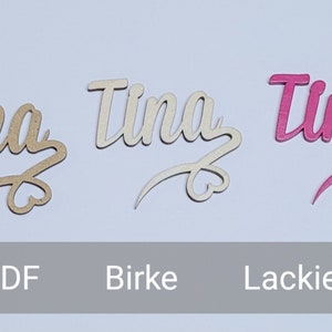 May include: Three wooden name signs with the name "Tina" written in a cursive font. The signs are made of MDF, birch, and painted pink.