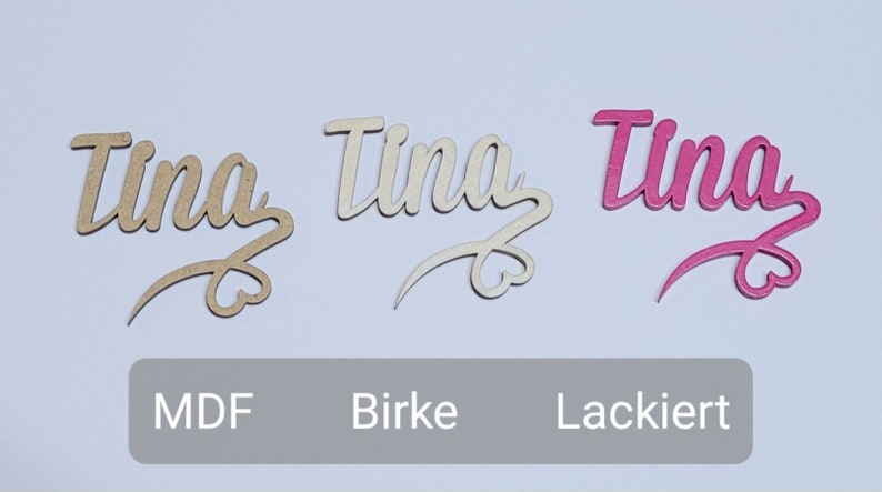 May include: Three wooden name signs with the name "Tina" written in a cursive font. The signs are made of MDF, birch, and painted pink.