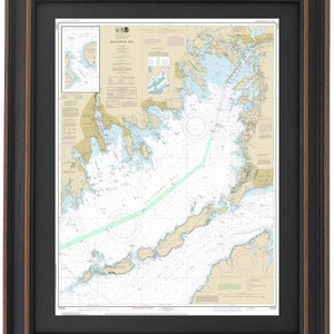 May include: A nautical chart of Buzzards Bay, Massachusetts, with detailed markings for navigation. The chart is framed in a black and brown wood frame.
