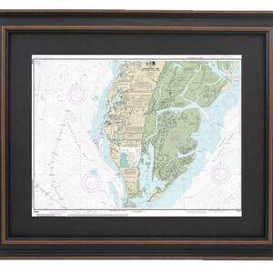 May include: A nautical chart of the Chesapeake Bay, printed on paper and framed in a black and brown wood frame.