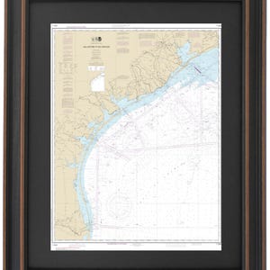 May include: Framed nautical chart titled "Galveston to Rio Grande." The chart features detailed coastlines, waterways, and navigational markers in shades of blue, beige, and white. The frame is black with a brown inner edge.