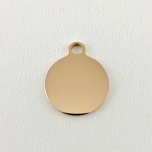May include: A gold-colored round metal tag with a hole at the top for attaching a chain or string.