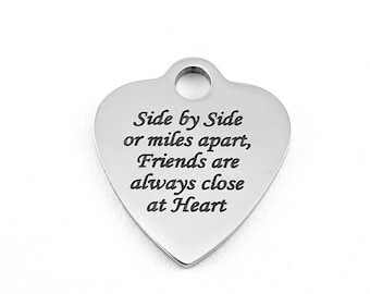 May include: Silver heart-shaped charm with the inscription "Side by Side or miles apart, Friends are always close at Heart".