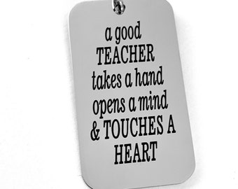 May include: A silver keychain with the inscription "a good TEACHER takes a hand opens a mind & TOUCHES A HEART".