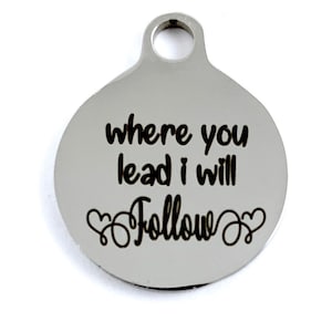 Peut inclure: Breloque ronde en argent avec le texte "where you lead I will follow" et deux cœurs.