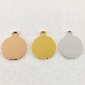 May include: Three round metal tags with a loop at the top. The tags are in rose gold, gold, and silver.