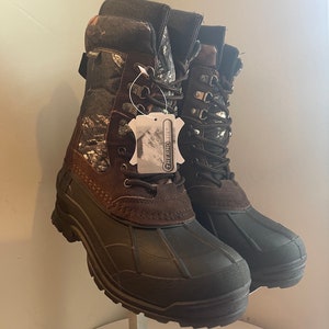 May include: A pair of insulated winter boots. The boots have a dark brown rubber base, a brown suede midsection, and a camouflage patterned upper. The boots have laces and a tag that reads "THERMOLITE".