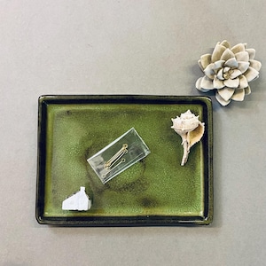 May include: A green ceramic tray with a seashell, a small white house, and a package of gold jump rings.
