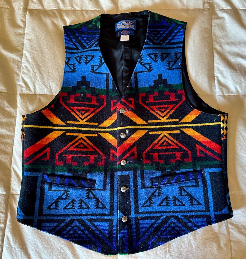 Puede incluir: Un chaleco estampado con cuello en V y cierre de botones. El dise&ntilde;o presenta formas geom&eacute;tricas en azul, rojo, amarillo y verde. El chaleco tiene dos bolsillos delanteros y un forro negro. La marca "Pendleton" es visible en una etiqueta.
