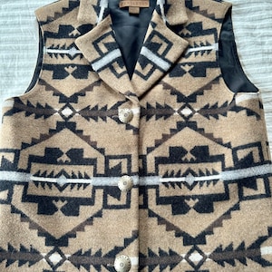 May include: A brown, black, and white Pendleton wool vest with a geometric pattern. The vest has a black lining and a button closure. The vest has a label that says "Pendleton" on it.