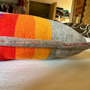 May include: A white ceramic mug with a black handle and the text "But First, Coffee" in a black, bold font. The mug is on a wooden surface. The mug is 10 cm tall.