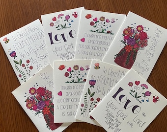 May include: A set of eight colourful cards with floral designs and inspirational quotes. The quotes include "In Christ Alone I Found My Hope", "Love Your God with All Your Heart, All Your Soul, All Your Mind, All Your Strength", "For The Joy Of The Lord Is My Strength", and "Though one may be overpowered, two can defend them. A cord of three is not easily broken."