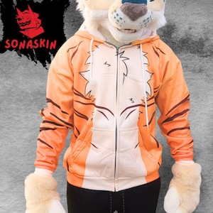 May include: Orange and cream-colored tiger-striped zip-up hoodie with a matching tiger head and paw gloves. The hoodie features a detailed tiger stripe design and the text "SONASKIN" in red.