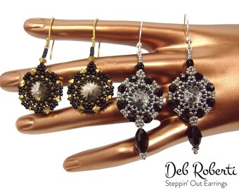 May include: Four pairs of beaded earrings in black, gold, and silver tones. Two pairs have gold-colored hooks and accents, while the other two have silver-colored hooks. Each earring features a central clear crystal surrounded by beads. The earrings are displayed on a bronze-colored hand.
