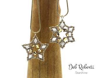 Könnte beinhalten: Zwei goldene Kettenhalsbänder mit weißen und goldenen sternförmigen Anhängern. Die Sterne bestehen aus kleinen Perlen und haben ein geometrisches Design. Der Text "Deb Roberti Starshine" ist am unteren Rand des Bildes sichtbar.
