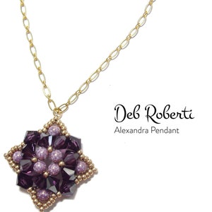 May include: A gold chain necklace with a purple and gold beaded pendant. The pendant is a starburst design with a geometric pattern. The text "Deb Roberti Alexandra Pendant" is visible below the pendant.