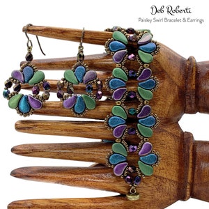 May include: A set of teal, purple, and green paisley swirl earrings and bracelet. The jewelry is made with seed beads and features a metallic finish.