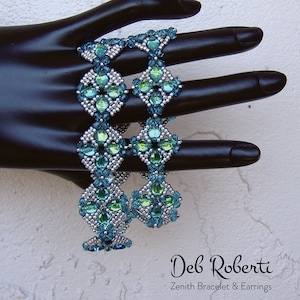 May include: Three beaded bracelets in a silver and turquoise colour scheme. The bracelets are made with small, faceted beads and are arranged in a geometric pattern. The bracelets are stacked on a black mannequin hand. The text "Deb Roberti Zenith Bracelet & Earrings" is visible at the bottom of the image.