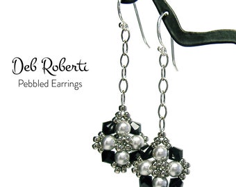 May include: A pair of silver dangle earrings with black and white beads. The earrings are on a display stand. "Deb Roberti Pebbled Earrings" is written below the earrings.