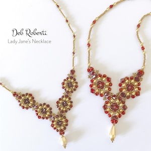 May include: Two beaded necklaces with the text "Deb Roberti Lady Jane's Necklace". The necklaces feature a gold chain with red and gold beads, and a central floral design with a teardrop pendant.