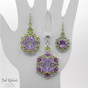 May include: A set of silver earrings and a pendant necklace featuring purple and green beaded flowers. The jewellery is crafted with small glass beads and silver wire.