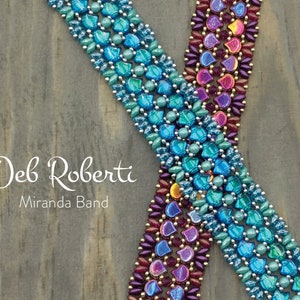 May include: Two beaded bracelets, one in shades of teal and blue, the other in shades of purple and red, with gold accents. The bracelets are on a wooden background with the text "Deb Roberti Miranda Band".