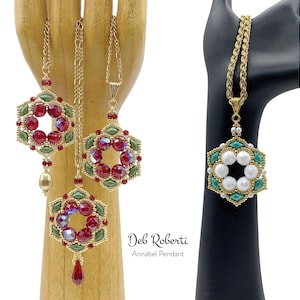 May include: Three gold chain necklaces with different pendant designs. The pendants are all hexagonal and feature a ring of red, green, or white beads. The text "Deb Roberti Annabel Pendant" is visible below the necklaces.
