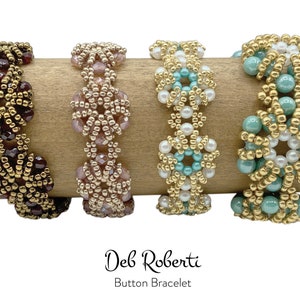 May include: Four beaded bracelets with gold, white, teal, and burgundy beads. The bracelets are arranged on a wooden surface. The text "Deb Roberti Button Bracelet" is below the bracelets.
