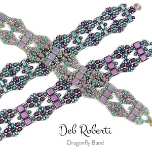 Op de afbeelding: Drie kralenarmbanden in tinten van paars, groen en goud. De armbanden zijn gemaakt met kleine, vierkante kralen en hebben een geometrisch patroon. De armbanden zijn in een kruislings patroon gerangschikt en de tekst "Deb Roberti Dragonfly Band" is zichtbaar onder de armbanden.